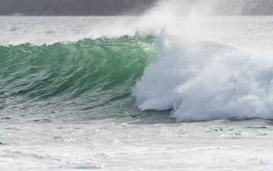 A breaking wave at Polzeath on the coast, North Cornwall, England UK
