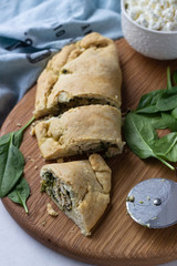 Closed pizza calzone with spinach, chicken and ricotta. Italian food.