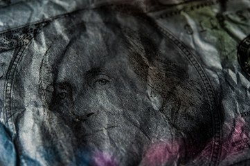 Fototapeta premium Closeup Benjamin Franklin on the 100 dollar grunge art abstract background. Dark, gloomy, crumpled.