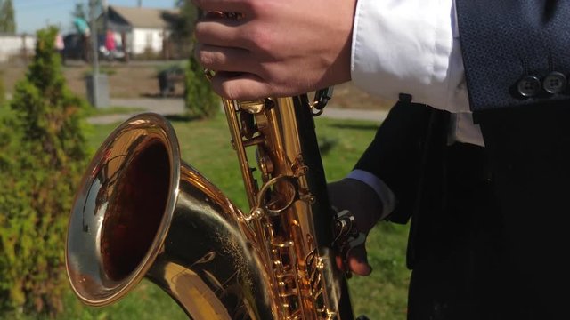 man playing saxophone jazz music. Saxophonist in dinner jacket play on golden saxophone. Live performance. concept of music business. Street musician.