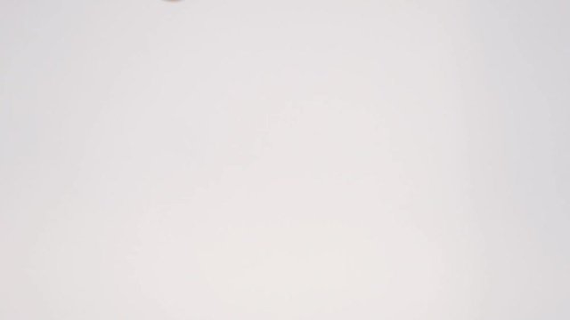 Slow motion of many tangerines mandarins tossed up to the air one by one on white background. Lots of mandarins juggled on white baackground.