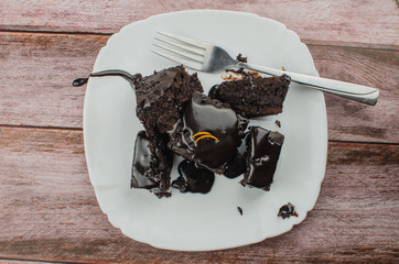 Sliced homemade brownies on white plate. Served on rectangle white plate. Favorite chocolate dessert for chocolate lover. Sweet and moist of cocoa taste. Top view.