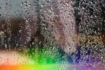 Abstract blurred colorfull rainbow aurora borealis on window glass with raindrops with multicolored lights with free copy space for text
