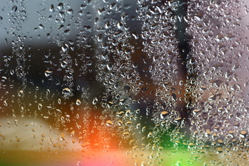 Abstract blurred amazing colorfull background rainbow aurora borealis on window glass with raindrops with multicolored lights with free copy space for text