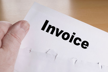 hand holding invoice letter with opened envelope 