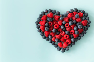 Forest fruit, raspberries and berries arranged in the shape of a heart with place for a text