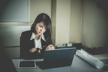 Asian woman working in office,young business woman stressed from work overload with a lot file on the desk,Thailand people thinking something