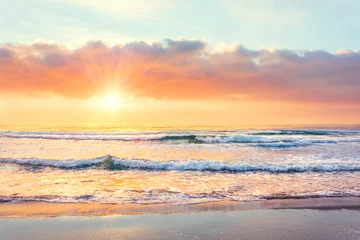 Sierkussen Ocean wave on the beach at sunset time, sun rays. © aapsky