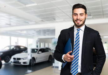 Car dealer smiling in a car saloon