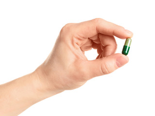 Woman holding spirulina pill on white background, closeup