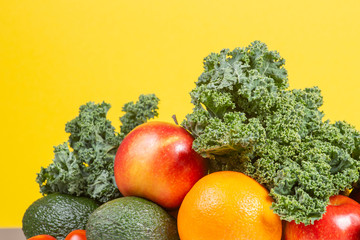 Fresh raw vegetables and fruits. Healthy eating background with orange, apples, kale, broccoli, orange, tomato, avocados