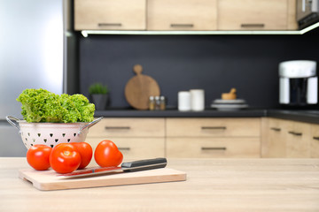 Fresh vegetables on wooden table in kitchen. Space for text