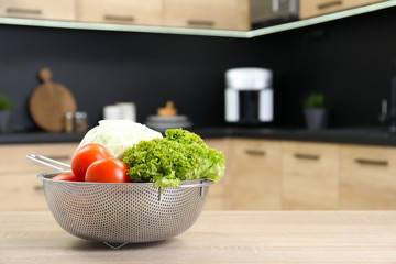 Fresh vegetables on wooden table in kitchen. Space for text