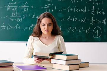 Young female math teacher in front of chalkboard  
