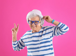 Portrait of cool grandmother on color background