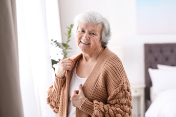 Portrait of beautiful grandmother in sweater at home