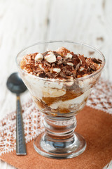 Trifle. Homemade Layered dessert made of biscuit and cream cheese (mascarpone or yogurt) with chocolate and nuts in a glass. Tiramisu. Cheesecake. Selective focus and copy space