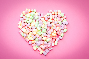 Air delicious romantic heart of tender multi-colored marshmallow on a pink background