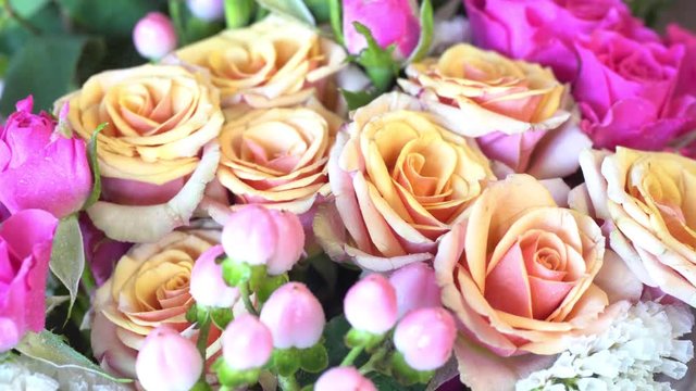 Spraying of beautiful bouquet of bright pink and beige roses.