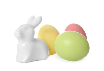 Cute ceramic Easter bunny and dyed eggs on white background