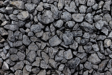 Background from a round dark stone. Dark pebble coal closeup folded. Rectangular photo.