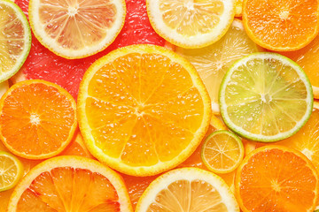 Slices of fresh citrus fruits as background, top view