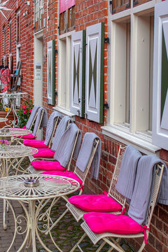 Altmodisches Strassen cafe mit lila pinkfarbenen Kissen und Decken im holl&auml;ndischen Viertel in Potsdam