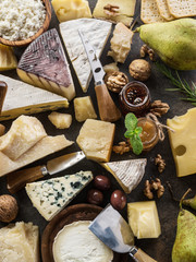 Assortment of different cheese types on stone background. Top view.