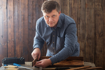 Fototapeta na wymiar carpenter working with tools on wooden background