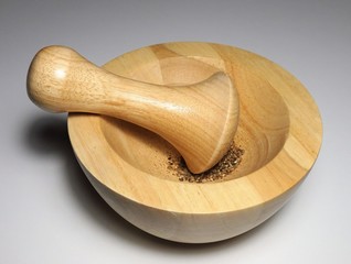 Mörser und Stößel aus Holz vor weißem Hintergrund