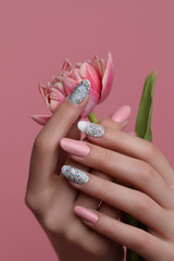 Nails  Art Design. Hands With pink Manicure On pink Background. Close Up Of Female Hands With Trendy pink Nails with spring flower. 