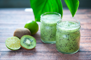 Kiwi smoothies in glass cups on a wooden table