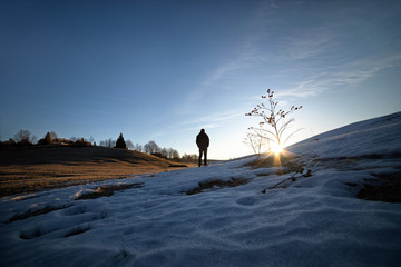 In the mountains, the man is watching the sunrise.