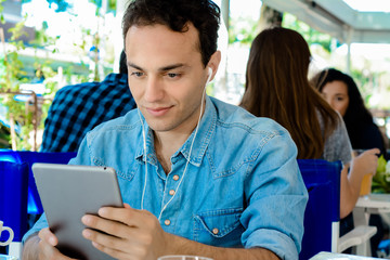Young man with tablet in coffee shop.