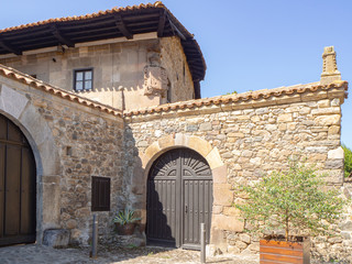 Fototapeta na wymiar Vistas de una fachada antigua con una puerta en el pueblo de Potes en Asturias, verano de 2018