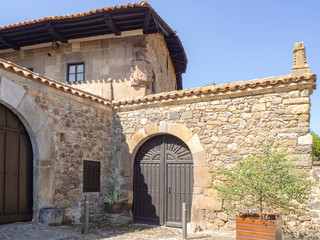 Fototapeta premium Vistas de una fachada antigua con una puerta en el pueblo de Potes en Asturias, verano de 2018