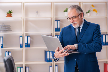 Fototapeta premium Aged male employee working in the office 