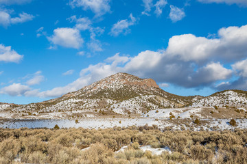 A winter Utah landscape,  with snow on a mountain and a blue sky overhead