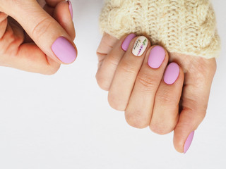 Fashionable lilac manicure design in the hand.