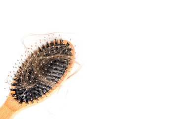 Wood hairbrush on white background. Close-up with long brown hair