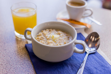 oatmeal on a blue background with orange juice and coffee