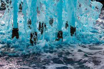 foreground in horizontal view of a source expelling blue water