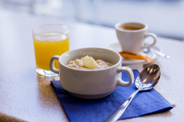 oatmeal on a blue background with orange juice and coffee