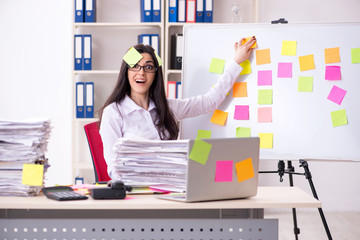 Young female employee in conflicting priorities concept 