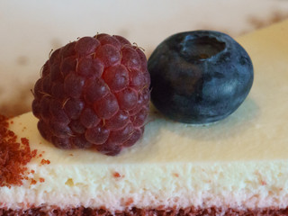 Close up image of the slice of a delicious cake with raspberries