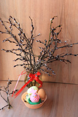 Fototapeta premium Willow branches and eggs on a wooden background, spring and willow after the rain say about the approach of Easter and a new life