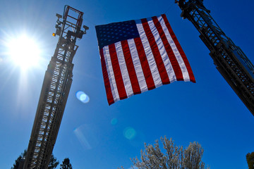 American flag flown from fire truck ladders