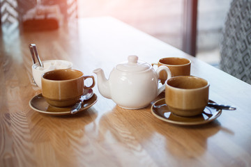 Teapot with cups on the table