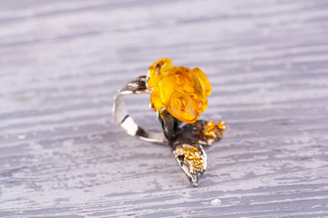 A silver ring with an insert of carved amber of honey color in a look to a frog