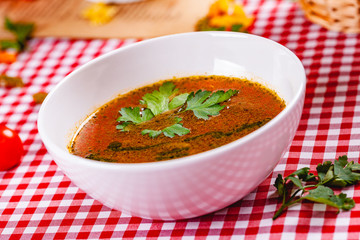 Vegetable soup with pesto sauce in white bowl. Close up